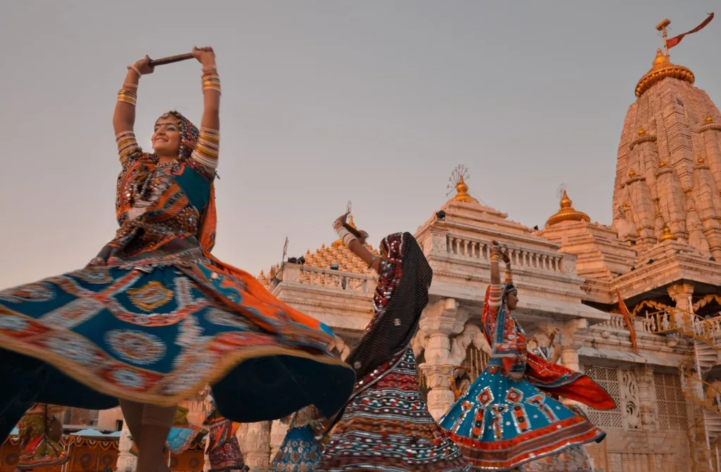 Garba and dandiya dancers in embroidered chaniya choli performing at Ambaji temple in Gujarat — Ambaji is the main temple of goddess Amba (Durga/Shakti), the deity whom Navratri and garba celebrate as the primordial feminine creative force