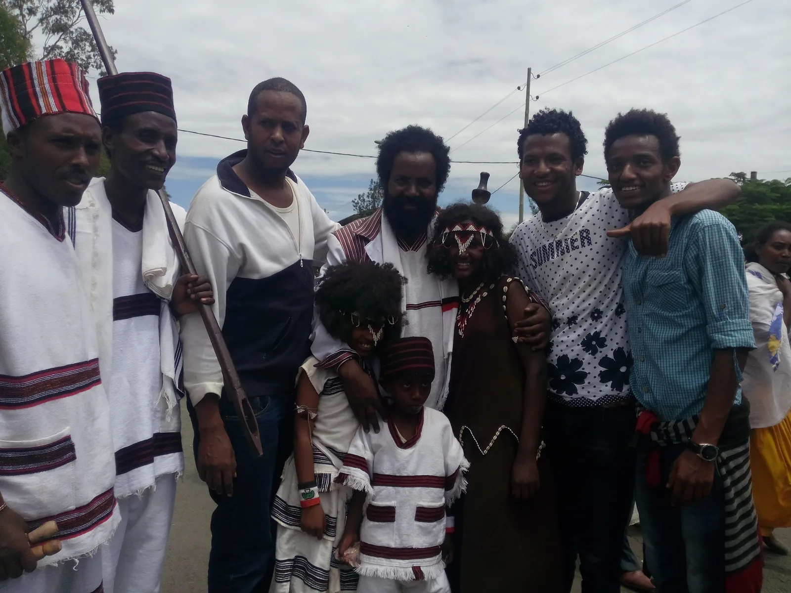 Group of Oromo people in traditional white shema robes with red black borders and beaded accessories at Irreechaa festival Ethiopia — Oromo cultural traditions including Gada system and Shuwalid UNESCO Intangible Cultural Heritage