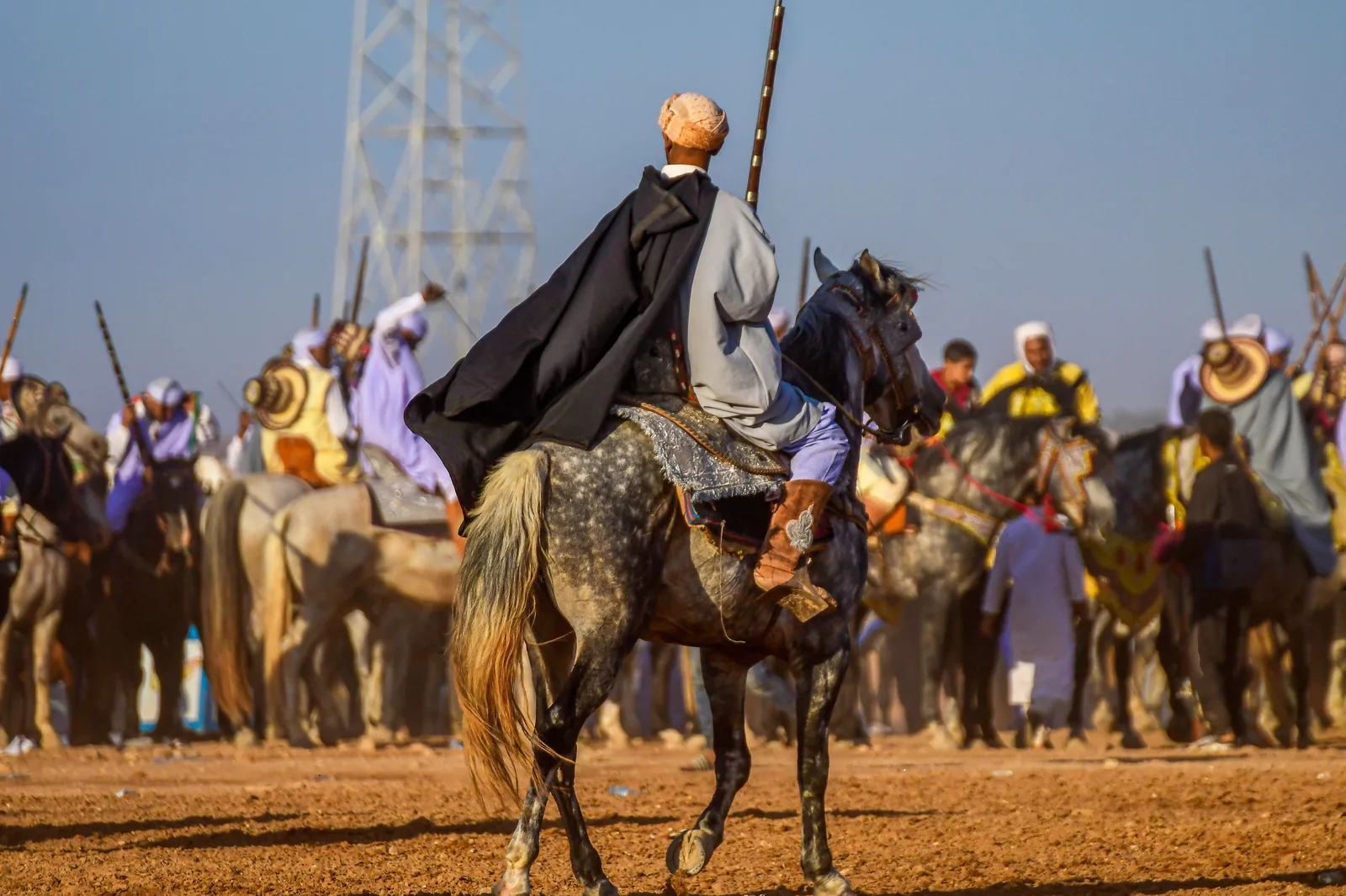 Moroccan Tbourida rider in traditional djellaba on horseback holding muzzle-loading rifle during Fantasia equestrian performance Morocco — Tbourida UNESCO Representative List Intangible Cultural Heritage of Humanity 2021