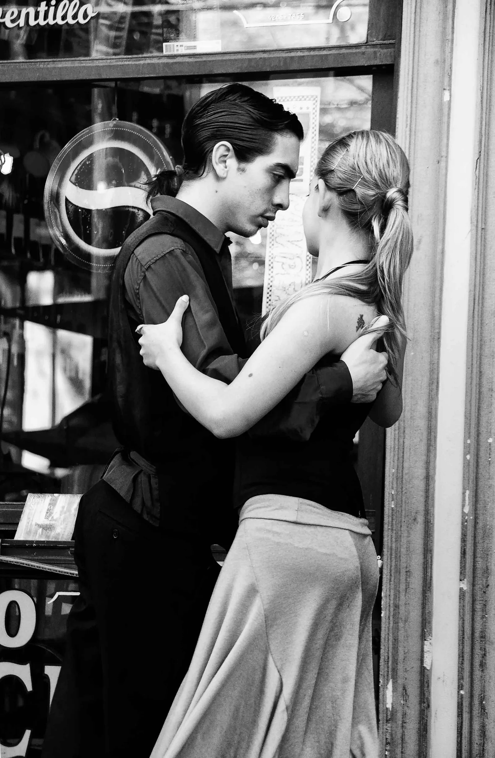 Young couple in close embrace dancing tango on a street in La Boca neighborhood of Buenos Aires (2011) — tango de salón's characteristic close embrace and walking technique is one of the social dance styles transmitted through the milonga under UNESCO's inscription File 00258