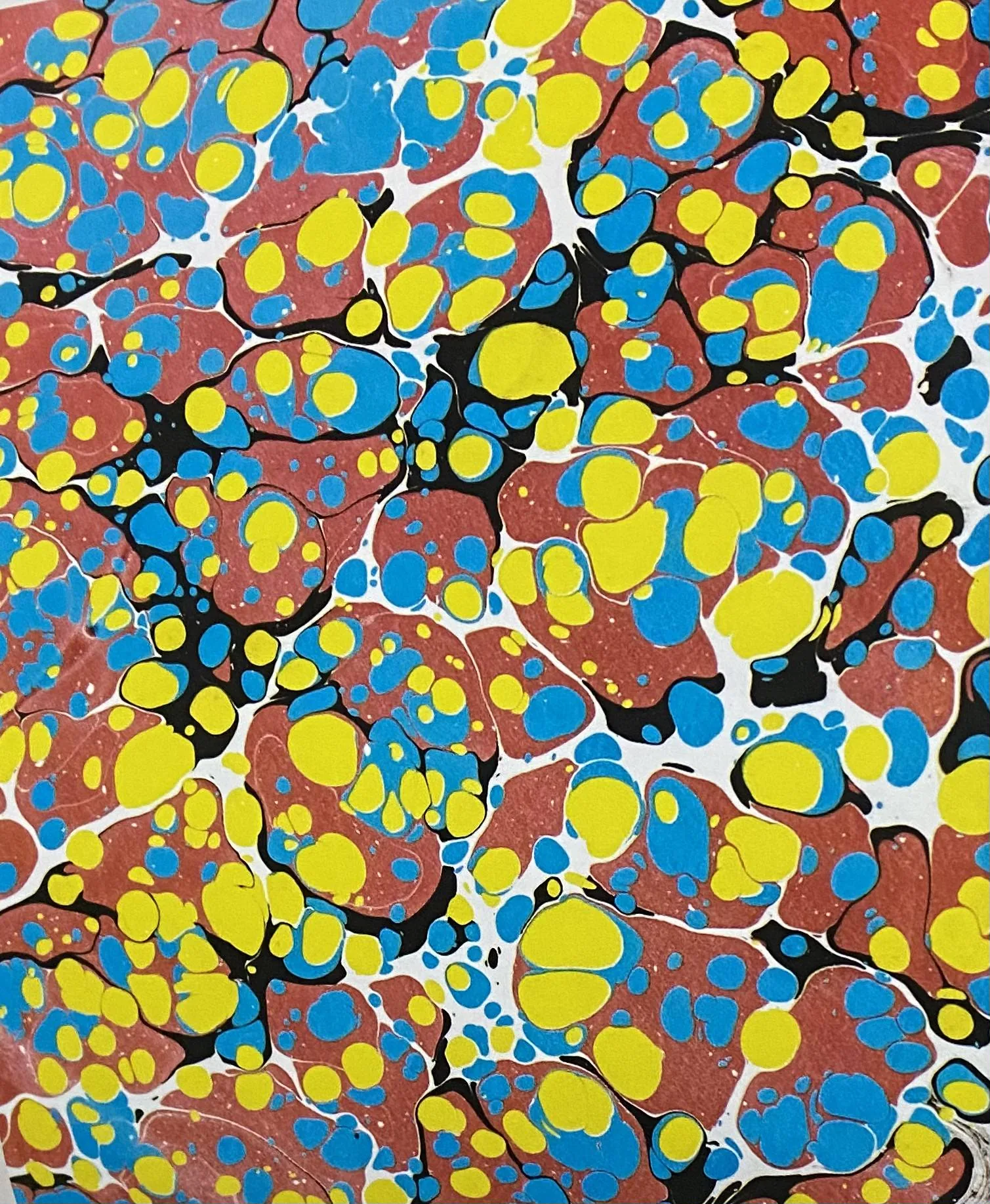 Battal Ebru Turkish paper marbling art showing characteristic organic patterns in red, yellow, and blue pigments floated on water — UNESCO Representative List File No. 00644, inscribed 2014