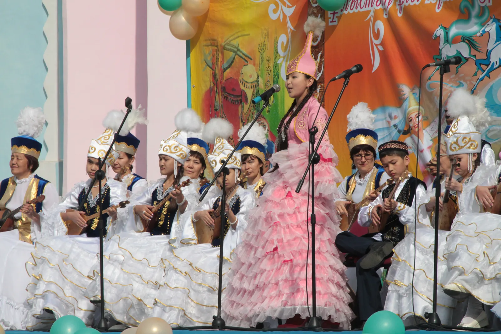 Kazakh Nauryz celebration with performers in traditional white-and-gold costumes playing dombra instruments (Kazakhstan, March 22 2013) — Nowruz is inscribed on UNESCO's Representative List of the Intangible Cultural Heritage of Humanity and exemplifies the social practices, rituals and festive events domain of the 2003 Convention